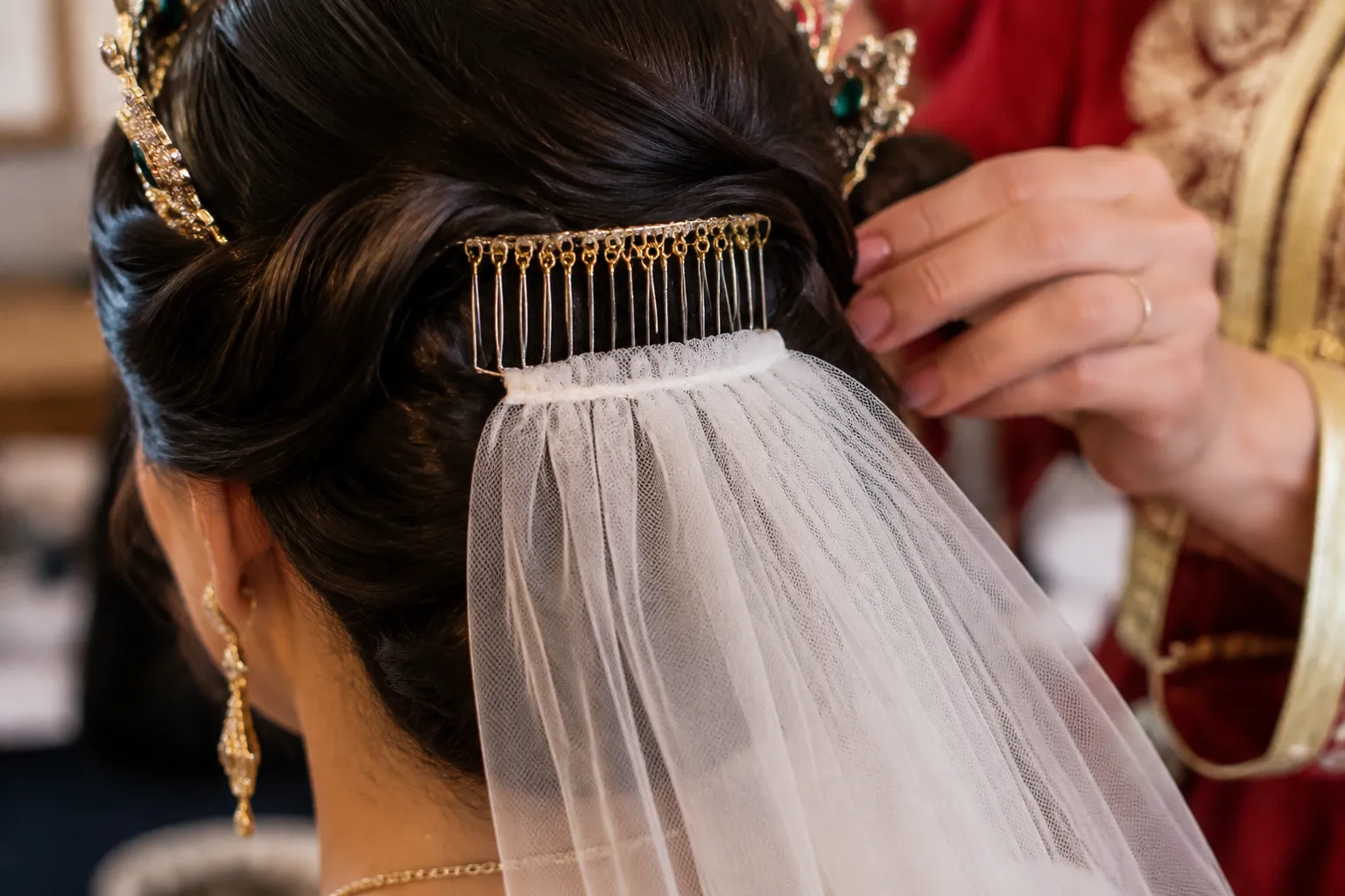 Close view of bridal veil comb, crown attachment, and styled hair during a fitting